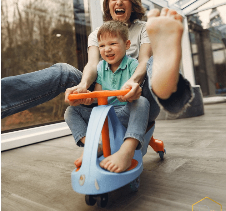 intuitive parenting: a woman and child on a toy bike laughing and having fun